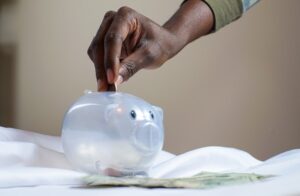 Inserting coin to piggy bank 300x196 - Inserting coin to piggy bank
