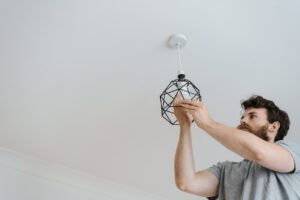 Man screwing light bulb into lamp 300x200 - Man screwing light bulb into lamp