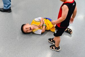 young boy lying on the ground in pain 300x200 - young boy lying on the ground in pain