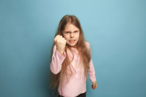 young girl holding fist up in anger 300x200 - young girl holding fist up in anger
