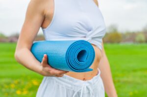 woman holding a blue yoga mat 300x199 - woman holding a blue yoga mat