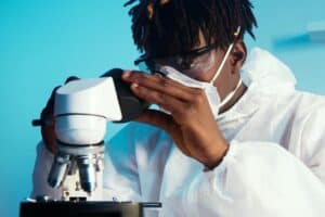 a man looking at the camera while holding the eyepiece of the microscope 300x200 - a man looking at the camera while holding the eyepiece of the microscope.jpg