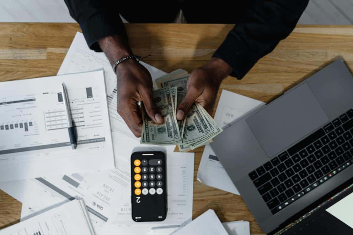 a person counting us dollars - Is Your Bookkeeping Costing You Money? (Discover Why)