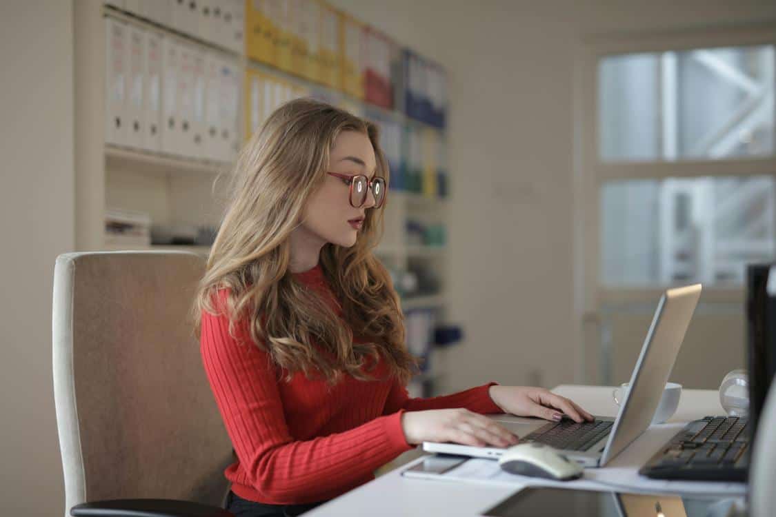 focused woman working using laptop - Is Your Bookkeeping Costing You Money? (Discover Why)