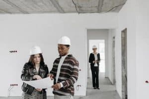 a couple wearing hard hats examines building plans inside an unfinished property with a realtor observing 300x200 - a couple wearing hard hats examines building plans inside an unfinished property with a realtor observing..jpg
