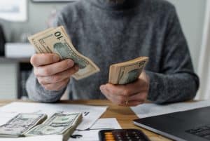 a person counting money 300x201 - a person counting money