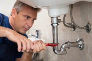 close up of a male plumber tightening a loose fitting 300x199 - close up of a male plumber tightening a loose fitting