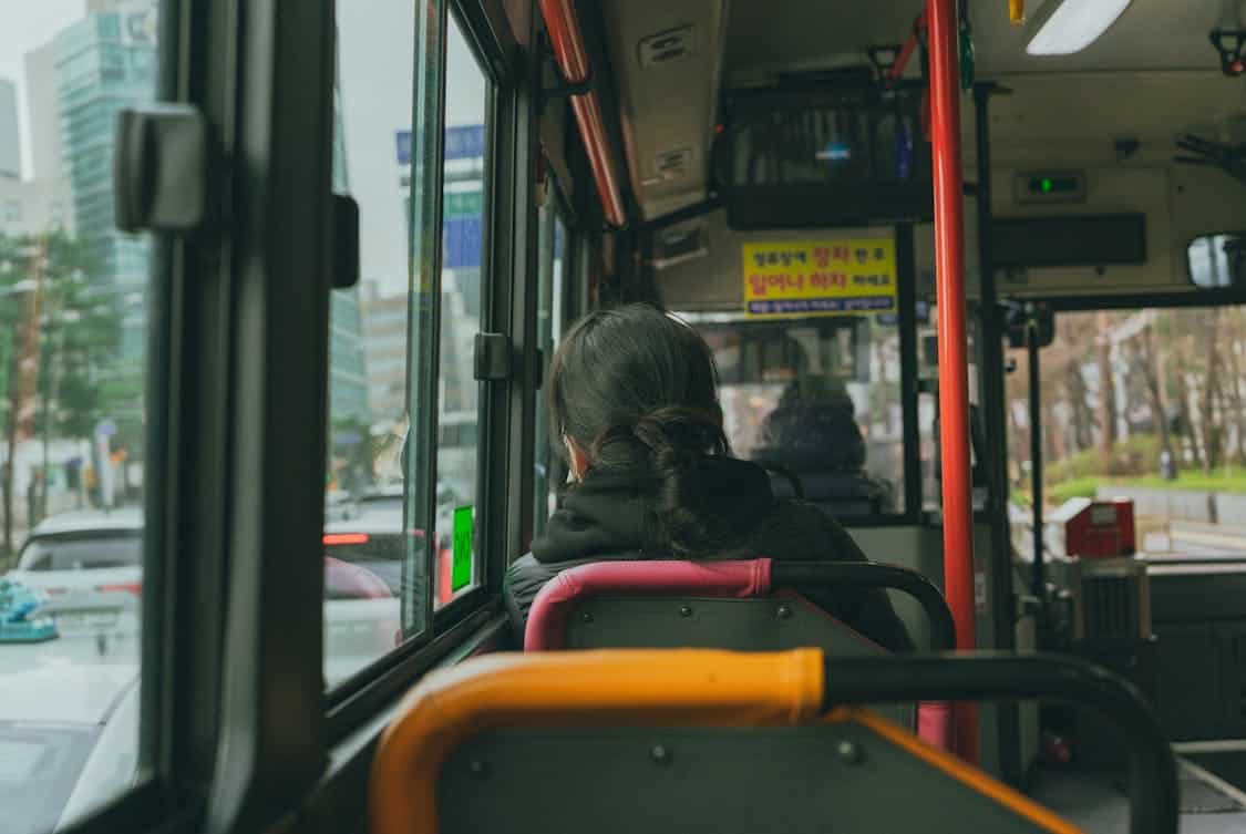 a commuter on a bus - How Shuttle Services Help Cut Daily Transportation Costs