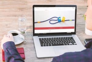a person holding a cup of coffee while using a laptop 300x201 - a person holding a cup of coffee while using a laptop