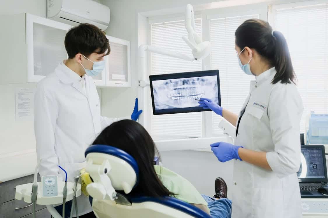 Hays County's Population Surge Is Straining the Dental Care Infrastructure Already There Two dentists examine a dental X ray with a patient - Hays County's Population Surge Is Straining the Dental Care Infrastructure Already There
