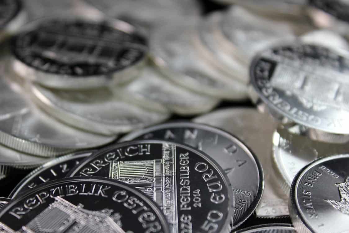 silver coins on a black surface - Is Your Portfolio Missing Silver? Here’s Why It Matters