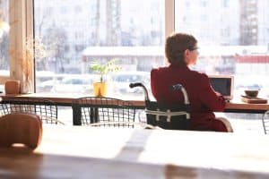 Woman in wheelchair using laptop at a cafe 300x200 - Woman in wheelchair using laptop at a caf&eacute;