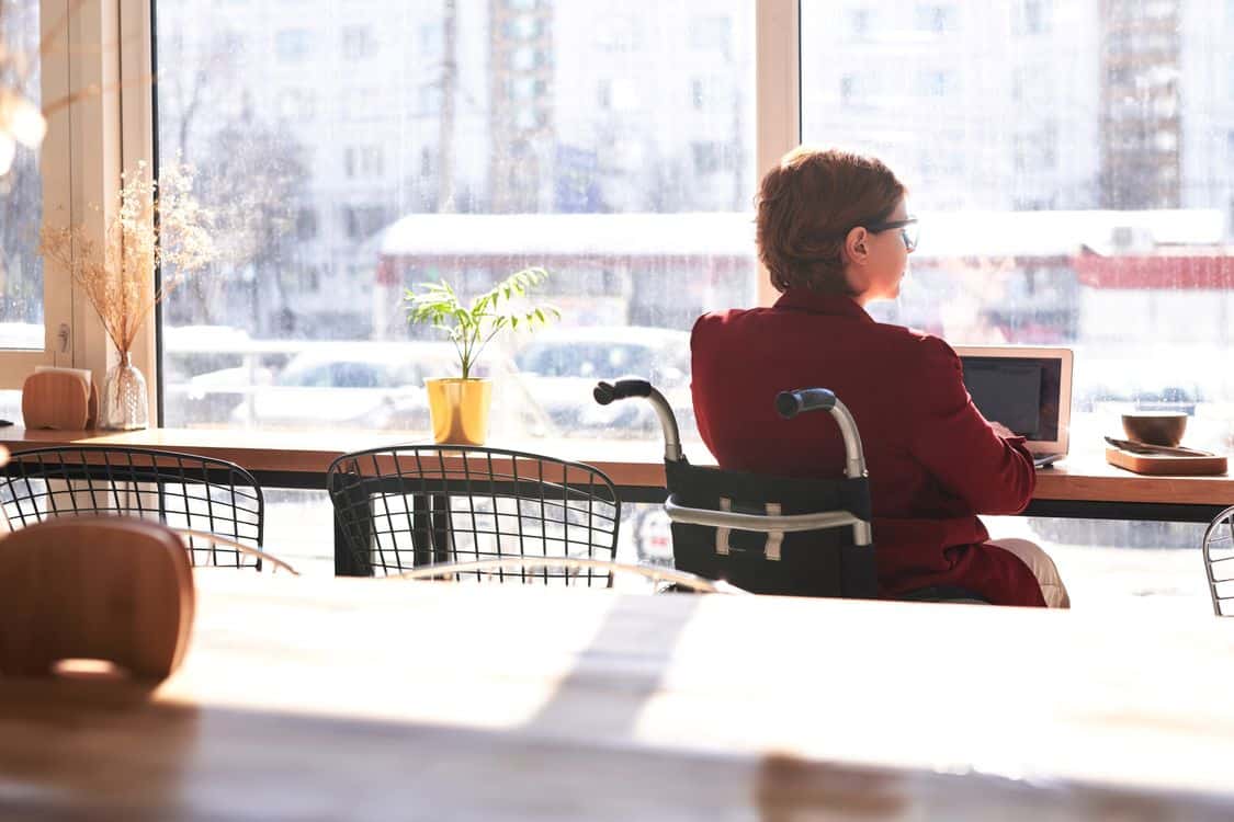 SSA Says Its Disability Backlog Is Shrinking. Arizona Applicants Tell a Different Story Woman in wheelchair using laptop at a cafe - SSA Says Its Disability Backlog Is Shrinking. Arizona Applicants Tell a Different Story