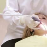 A dentist performing a dental procedure 150x150 - Home