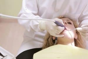 A dentist performing a dental procedure 300x200 - A dentist performing a dental procedure