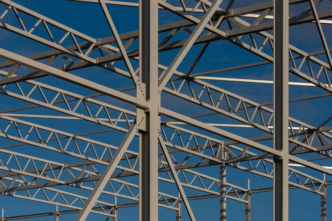 Detailed view of a steel framework structure - What the New Metals Tariffs Are Doing to Steel Costs on 2026 Industrial Job Sites